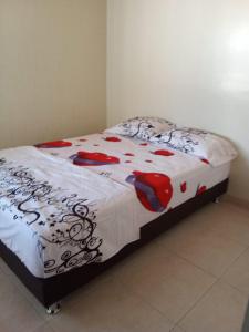 a bedroom with a bed with a white and red comforter at Acogedora Casa Flandes in Flandes