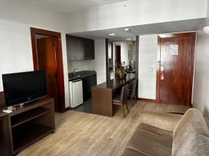 ブラジリアにあるHotel Bonaparte Flat Particular Cのソファとテーブル、テレビのあるリビングルーム