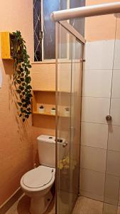 uma casa de banho com um WC e uma porta de duche em vidro. em Savassi Hostel em Belo Horizonte