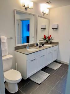 uma casa de banho com um lavatório, um WC e um espelho. em Ruby Getaway-Highrise, Balcony, Pool, City View! em Atlanta