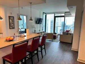 uma cozinha e sala de estar com um bar com cadeiras vermelhas em Ruby Getaway-Highrise, Balcony, Pool, City View! em Atlanta