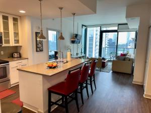 uma cozinha e sala de estar com uma grande ilha com cadeiras vermelhas em Ruby Getaway-Highrise, Balcony, Pool, City View! em Atlanta