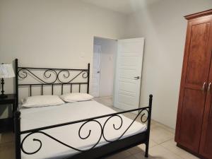 a bedroom with a black and white bed and a door at Robinson Villa..... your gateway to Carnival City. in Belmont