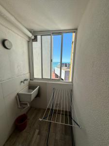 uma casa de banho com um lavatório e uma janela em Bolivar y Guemes. Vista al mar. em Mar del Plata