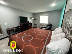 a bedroom with a bed and a living room at Super 8 by Wyndham Emporia in Emporia