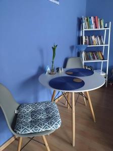 a table and two chairs and a book shelf at Pod Małą Sową in Walim