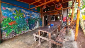 a room with a table and a mural on the wall at LA PIRATA Casa Hostel in Palomino
