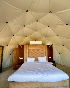 um quarto com uma cama grande numa tenda em Jabal Rum Camp em Wadi Rum