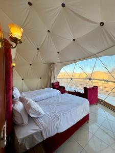 um quarto com uma cama grande numa tenda em Jabal Rum Camp em Wadi Rum