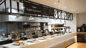 a buffet line with food on display in a restaurant at Holiday Inn Auckland Airport by IHG in Auckland