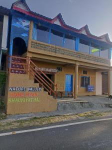 um edifício com um sinal em frente em Nature Valley Homestay Shaukiyathal em Panuānaula