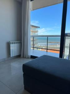 a bedroom with a bed and a view of the beach at Liniers, con vista al mar in Mar del Plata