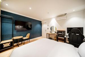 Habitación de hotel con cama y escritorio en Hound Hotel Gumi indong en Gumi