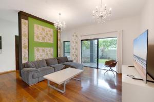a living room with a couch and a tv at Hope Island Haven Retreat in Gold Coast