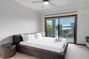 sypialnia z łóżkiem i dużym oknem w obiekcie Hope Island Haven Retreat w mieście Gold Coast