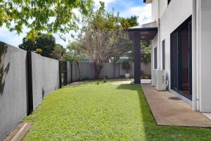 a backyard with a fence and grass at Hope Island Haven Retreat in Gold Coast