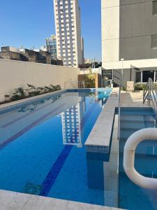 a large swimming pool in a city with a building at AP Smart Quirino in Campinas