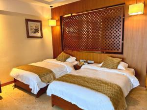 a room with two beds in a hotel room at Rainbow Valley Hot Spring Hotel in Gaizhou
