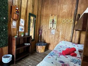 a bedroom with a bed and a wooden wall at Hostel Rústico MarAbi in Tarcoles