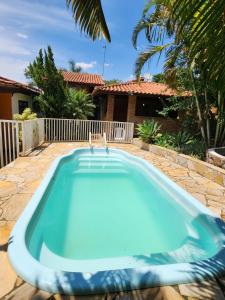 a swimming pool in front of a house at Área de Lazer com quartos e cozinha aberta na Chácara Refrigerio in Salto
