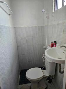 La petite salle de bains est pourvue de toilettes et d'un lavabo. dans l'établissement Mel's Place 2BR Apartment Unit1 in Batangas City, à Batangas City
