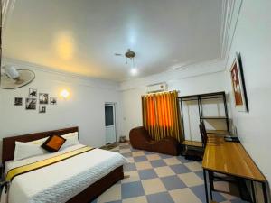 een slaapkamer met een bed en een bureau. bij Thắng Lợi Hotel in Thanh Hóa