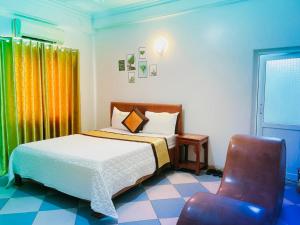 1 dormitorio con 1 cama y 1 silla en Thắng Lợi Hotel en Thanh Hóa