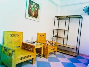Habitación con muebles de madera, mesa y sillas. en Thắng Lợi Hotel en Thanh Hóa