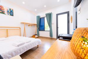a bedroom with a bed and a couch and windows at Nine Homestay in Can Tho