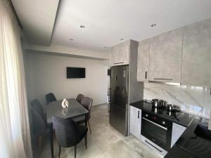 a kitchen with a table and a black refrigerator at THE WAVE HOUSE in Skala Sotiros