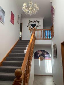 uma escada numa casa com um lustre em Riverdale Ensuite em Palmerston North