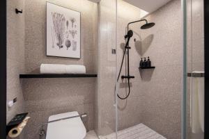 een badkamer met een douche en een toilet bij Atour S Hotel Ningbo Heyi Avenue in Ningbo