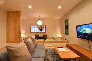 a living room with a couch and a tv at FL House 浪花町 in Osaka
