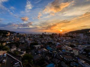 Blick auf eine Stadt bei Sonnenuntergang in der Unterkunft Ito Hotel Juraku in Ito