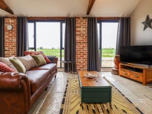 a living room with a couch and a flat screen tv at Little Owl in Market Rasen