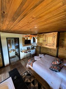 a bedroom with a bed and a wooden ceiling at Chalés Refúgio Ohana in Urubici