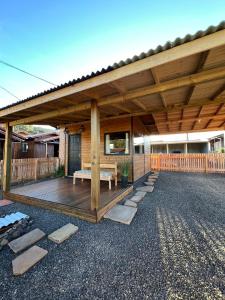 a wooden pergola with a bench on a deck at Chalés Refúgio Ohana in Urubici