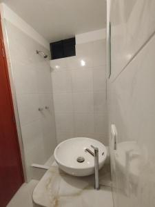 a white bathroom with a toilet and a shower at ALPHA69 in Cajamarca