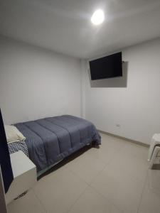 a bedroom with a bed and a flat screen tv at ALPHA69 in Cajamarca