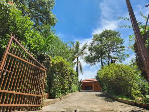 an entrance to a house with a gate and trees at Área de Lazer com quartos e cozinha aberta na Chácara Refrigerio in Salto