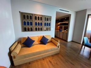 um sofá numa sala de estar com almofadas azuis em Apec Mandala Mũi Né - Khách Sạn Nghĩ Dưỡng Luxury Limited em Ấp Thiẹn Ái