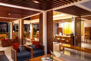 a lobby with couches and tables and a dining room at Javana Royal Villas in Seminyak