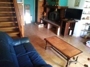 a living room with a blue couch and a coffee table at Maison de village avec jardin in Saint-Louis-et-Parahou