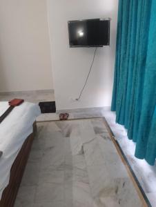 um quarto com uma televisão na parede e uma cama em Hotel Marina Hills em Solan