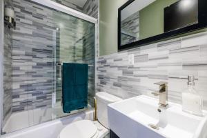 a bathroom with a sink and a toilet and a mirror at Park Side Living, City Style in New York