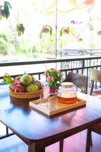 a wooden table with a tray of fruit on it at Nine Homestay in Can Tho