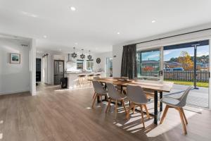 a kitchen and dining room with a wooden table and chairs at Motuoapa Getaway - Lake Taupo Holiday Home in Turangi