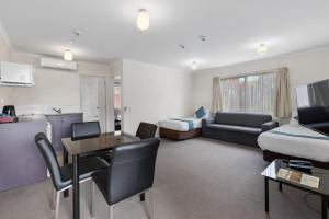 Sala de estar con sofá, cama y mesa en Best Western BKs Pioneer Motor Lodge, en Auckland