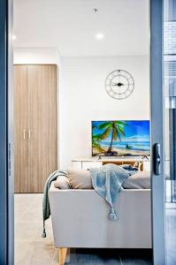 un soggiorno con divano e orologio sul muro di Comfy 1 Bedroom in Homebush a Sydney