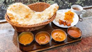 a tray of food with a basket of bread and dips at Henn na Hotel Tokyo Asakusabashi in Tokyo